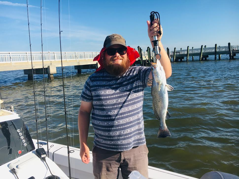 Happy fisherman in boat with fish.